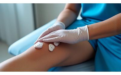 Fisioterapeuta aplicando gelo e eletroterapia em joelho lesionado de futebolista.
